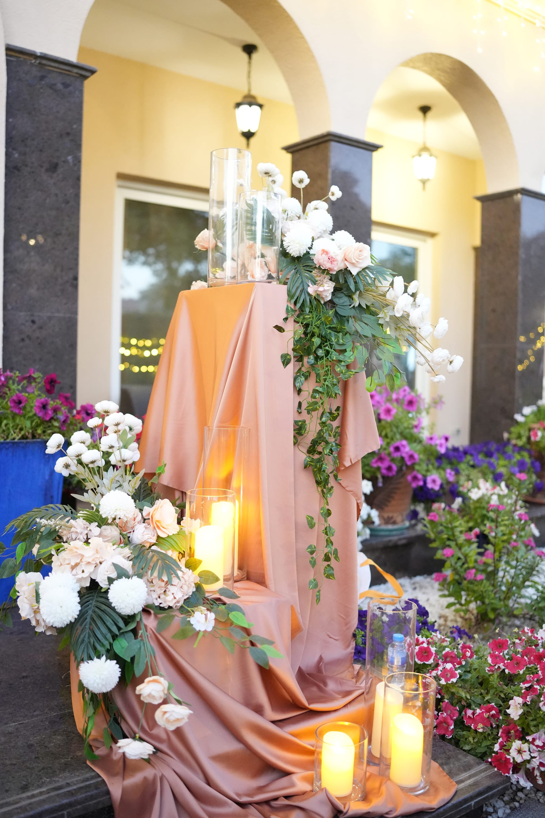 Entrance florals, draping, and candles under arched doorways