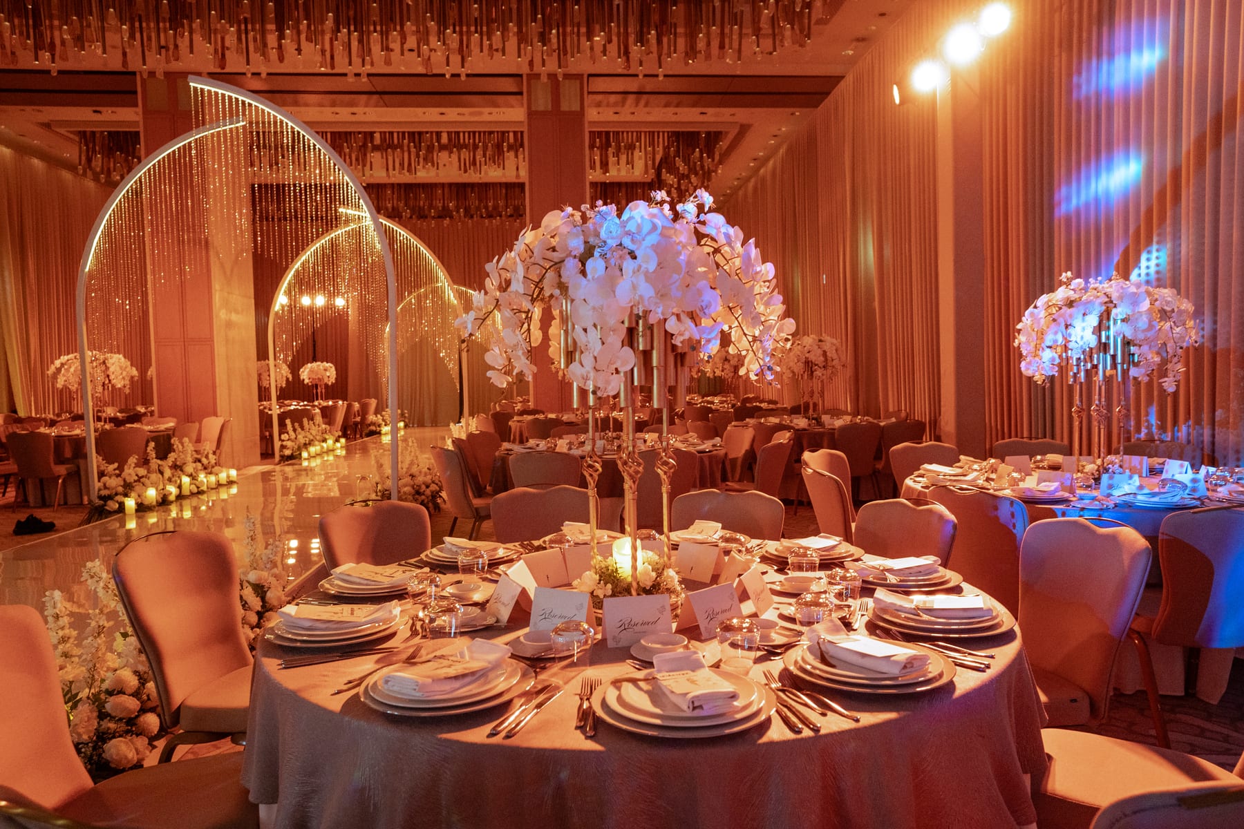 Reception tables set with white orchid centrepieces