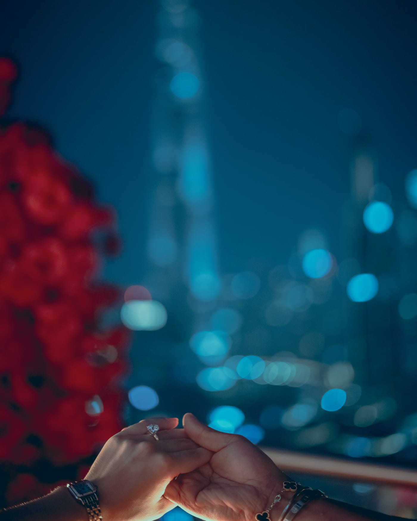 Engagement ring held against the evening skyline