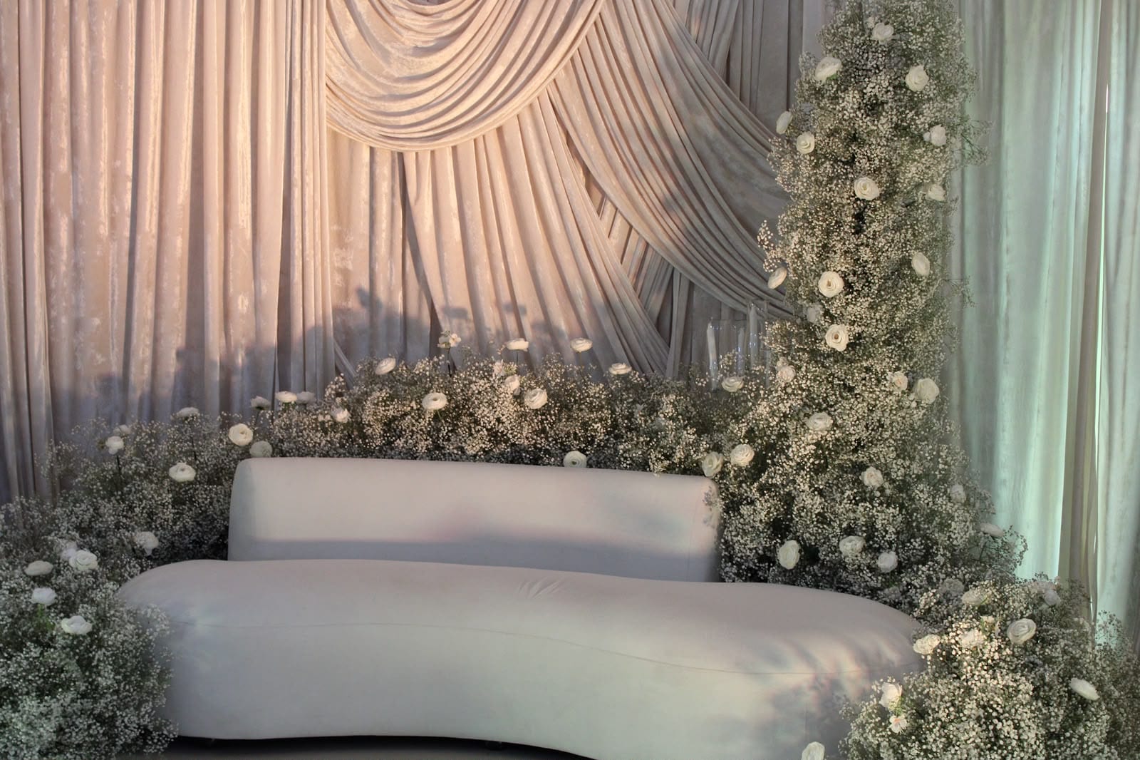 Ivory draped backdrop with a floral sofa