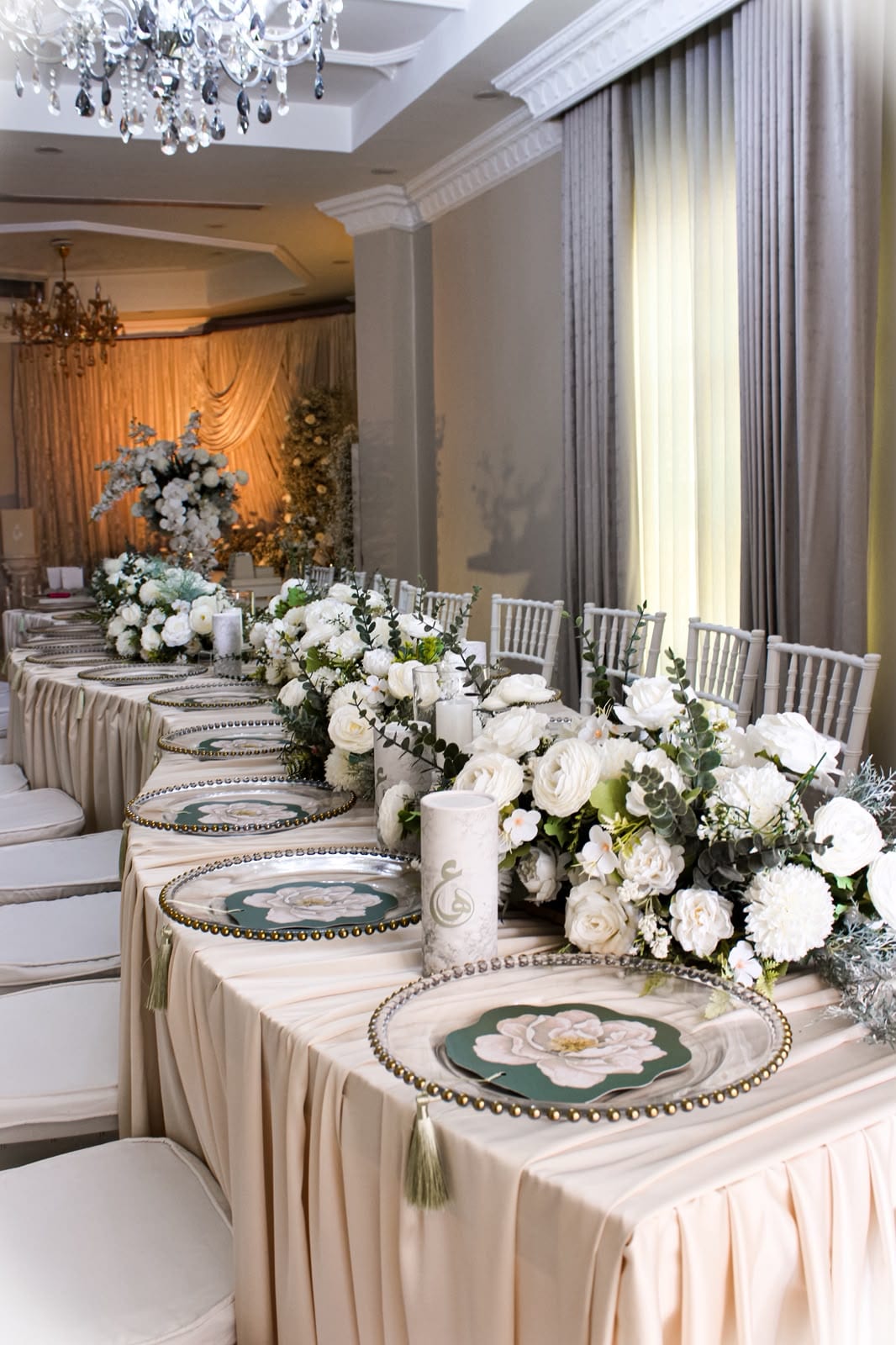Long banquet table with white florals and silver chargers
