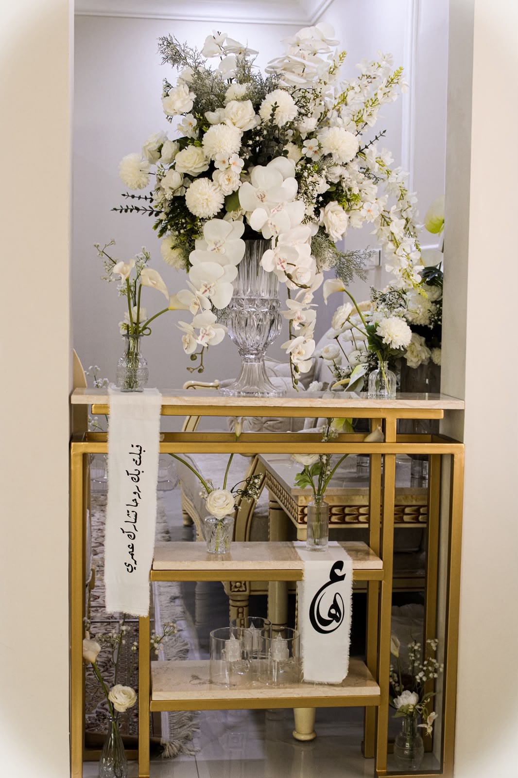 Orchids and calla lilies on a gold console