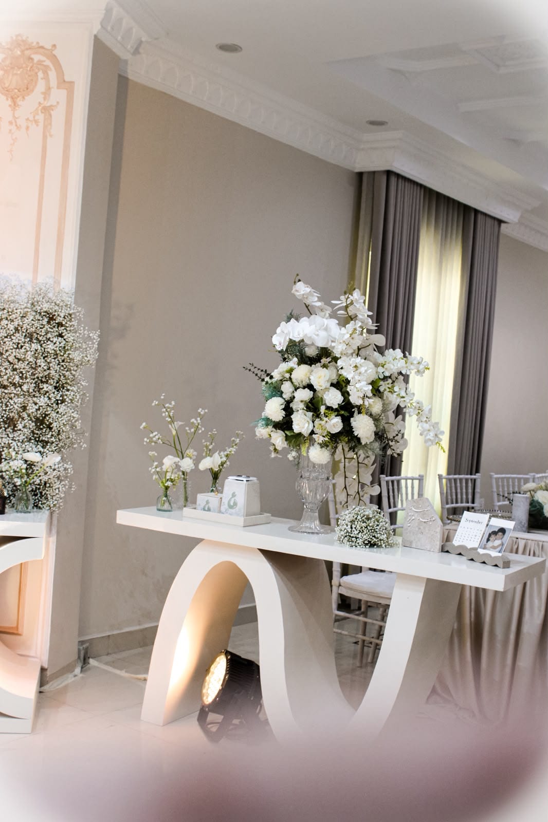 White floral arrangements along a console